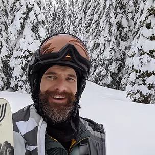 Daman with a beard, out in deep snow wearing ski equipemnt